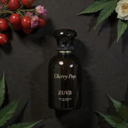 Zuva Cherry Pop perfume bottle with floral and berry decorations on a dark background